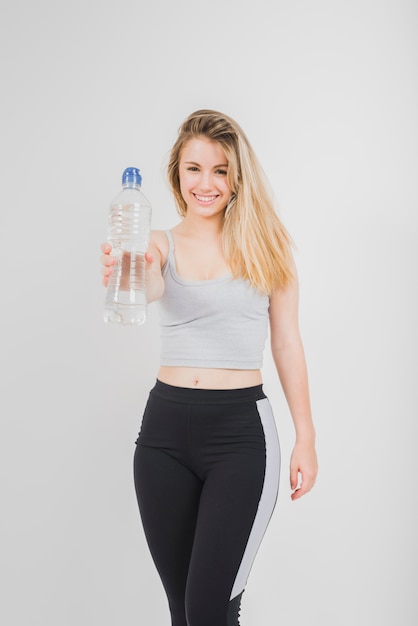 Foto gratuita ragazza sportiva che mostra bottiglia di acqua