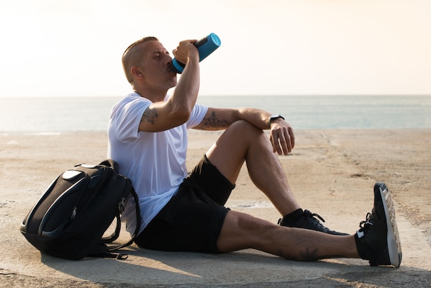 Free photo sporty male athlete being thirsty