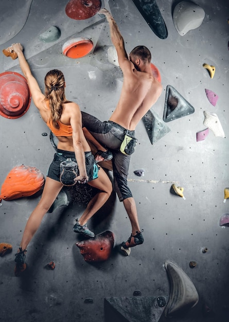 Foto gratuita sportivi maschi e femmine che si arrampicano su una parete da arrampicata.
