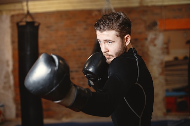 Sporty man boxing. Photo of boxer on a ring. Strength and motivation