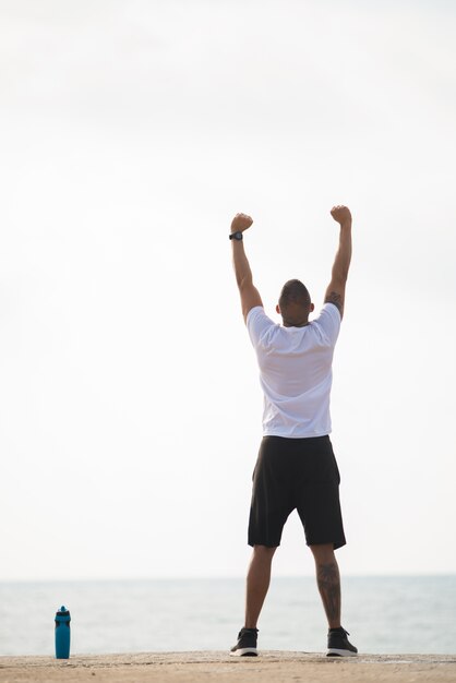 Sporty man contemplating seascape while exercising