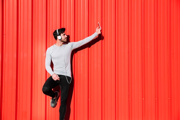 Free photo sporty man in headphones taking selfie