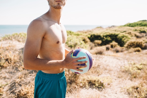 Sporty man holding volleyball