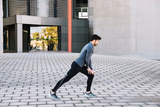 Sporty man lunging on street