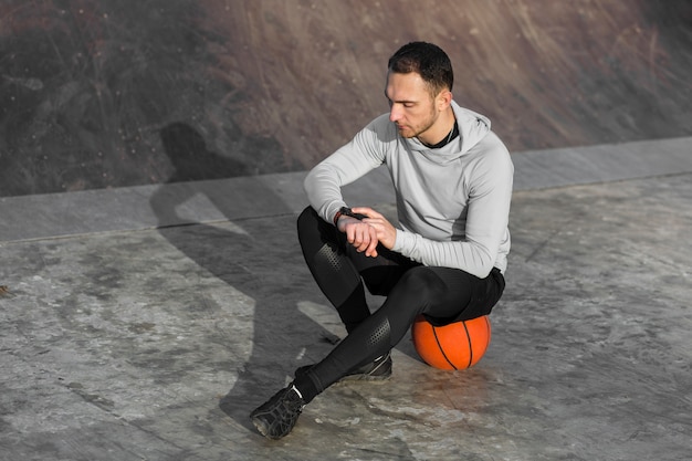 Спортивный человек отдыхает на баскетбольной площадке
