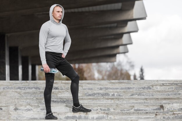 Sporty man sitting on stairs and posing fashion