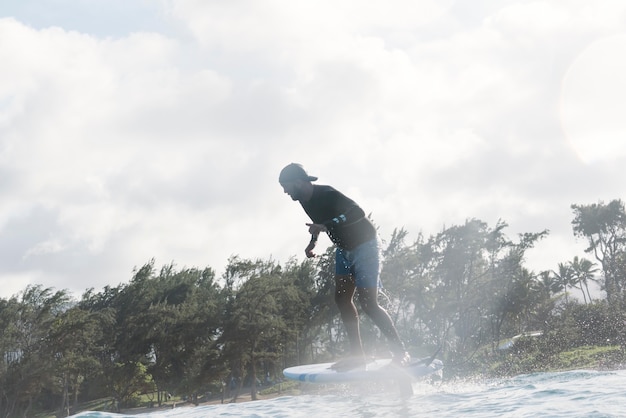 Uomo sportivo che fa surf alle hawaii