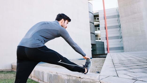 Sporty man warming up on street