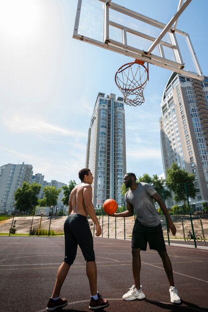 バスケットボールの低角度のビューを再生するスポーティな男性