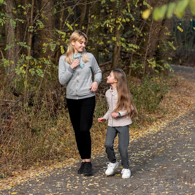 Sporty mother and daughter running in nature