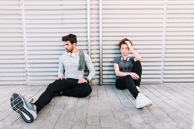 Sporty people resting near wall