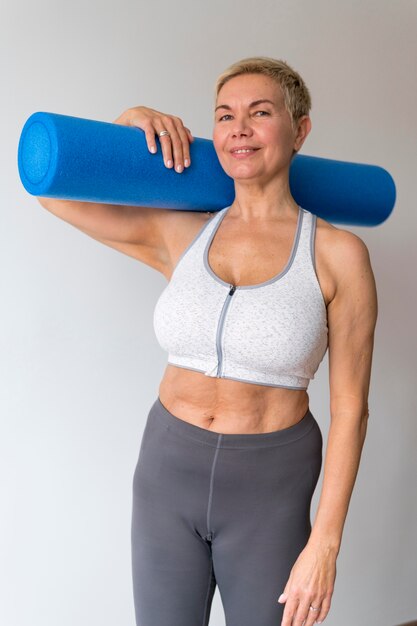 Sporty senior woman with short hair holding fitness accessory