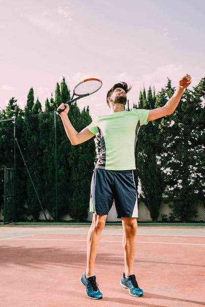 Sporty tennis player serving