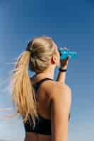 Free photo sporty woman drinking at the beach