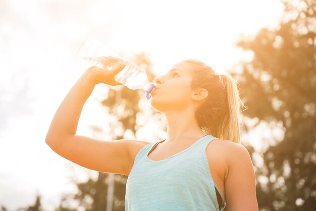 Sporty woman drinking on stadium track