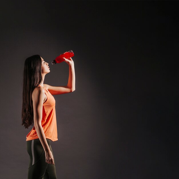 Sporty woman drinking water