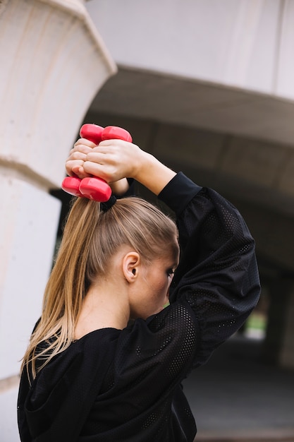 Sporty woman exercising with dumbbells