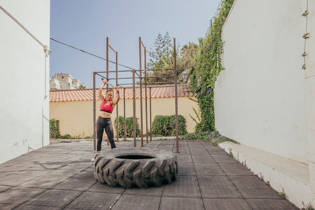 Sporty woman hitting wheel with hammer