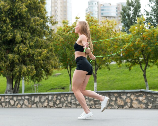 Sporty woman jumping skipping rope