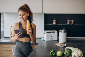 免费照片的女人在厨房里使用手机