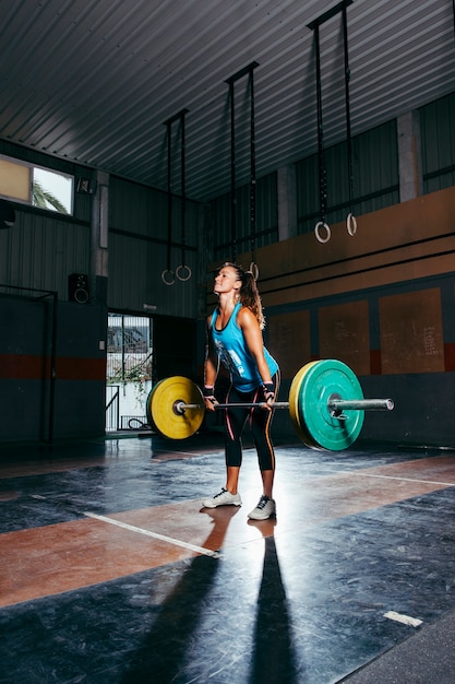 Free photo sporty woman lifting barbell