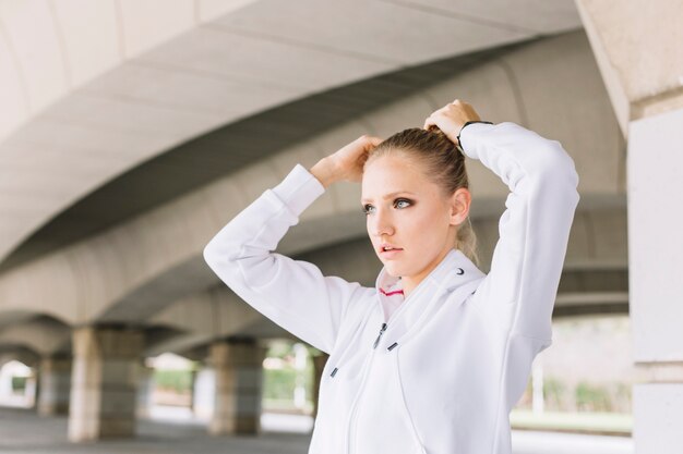 Sporty woman making ponytail