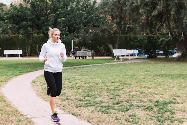 公園で走っているスポーティーな女性