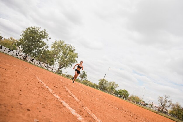 Sporty woman running on stadium track