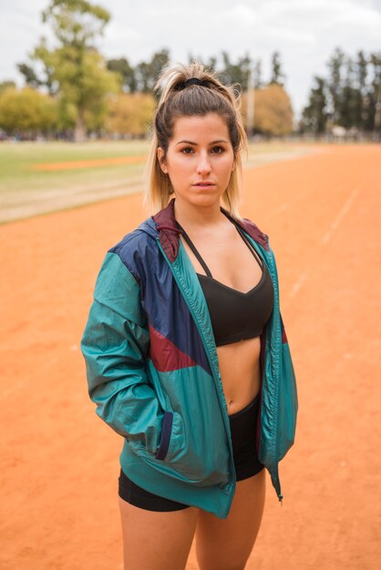 Sporty woman standing on stadium track