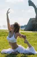 Free photo sporty woman stretching on lawn