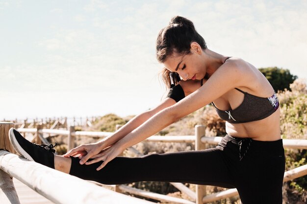 Sporty woman stretching leg