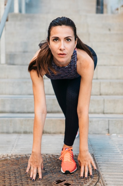 Foto gratuita donna sportiva che si estende in ambiente urbano