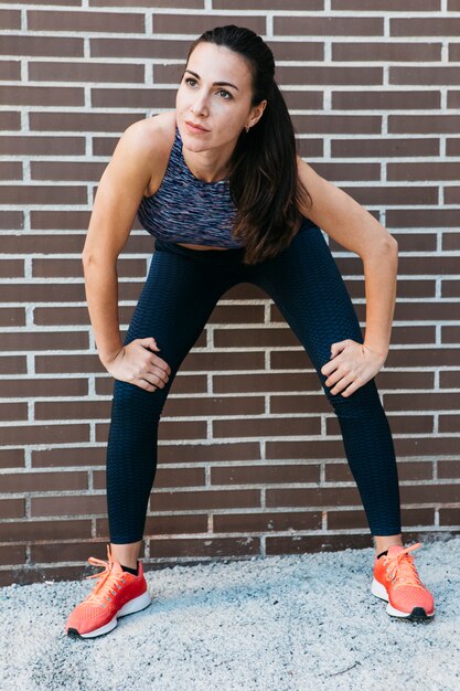 Sporty woman stretching in urban environment