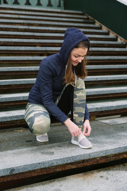 ステップで靴ひもを結ぶスポーティな女性