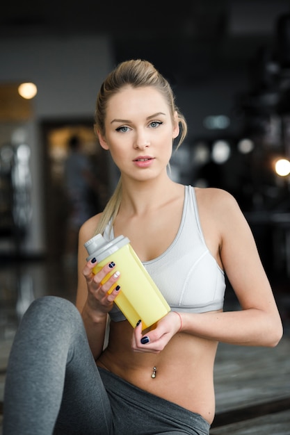 Sporty woman with bottle at the gym