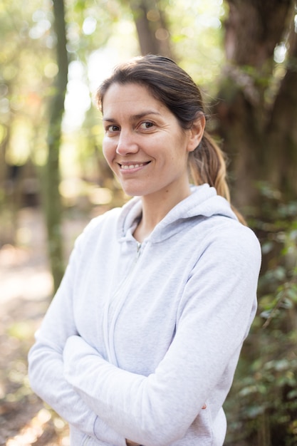 Sporty woman with crossed arms outdoors