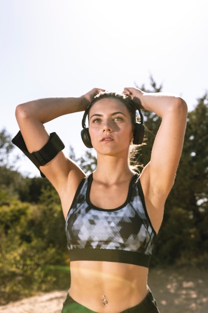 Sporty woman with headphones getting ready to run 