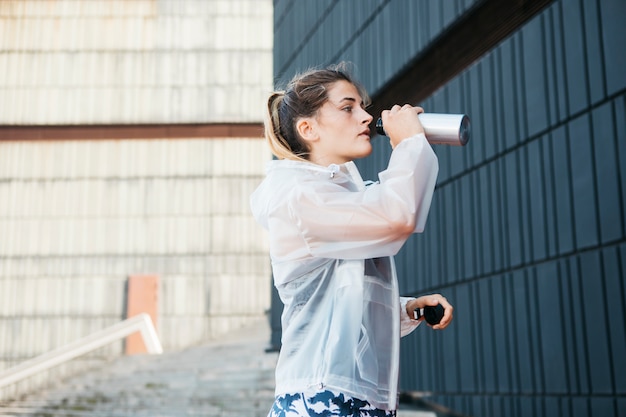 Donna sportiva con rainjacket in ambiente urbano