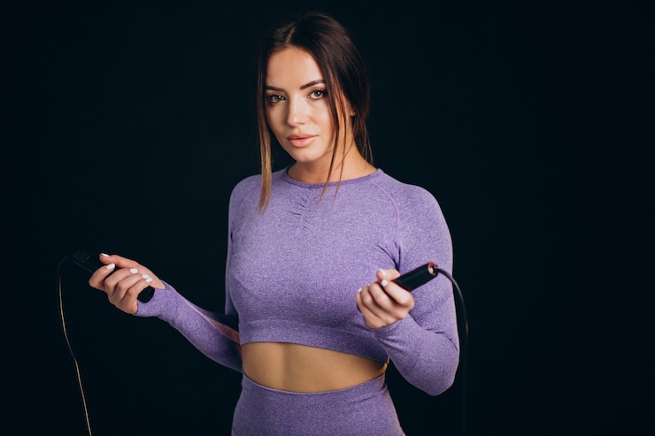 Free Photo sporty woman with skipping rope isolated on black background
