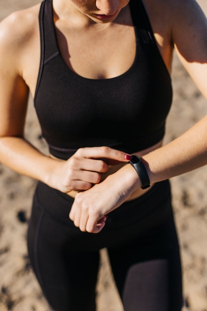 Donna sportiva con smartwatch in spiaggia
