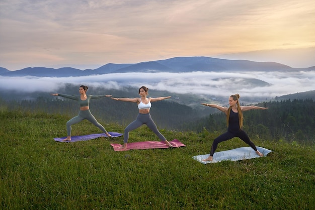 Foto gratuita donne sportive che fanno esercizi di yoga sulla natura