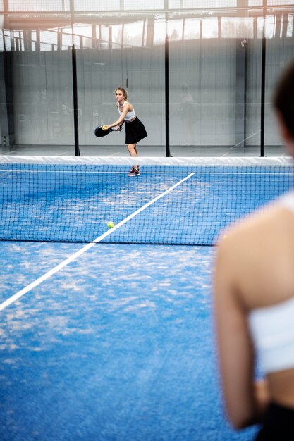 パドルテニスをするスポーティな女性