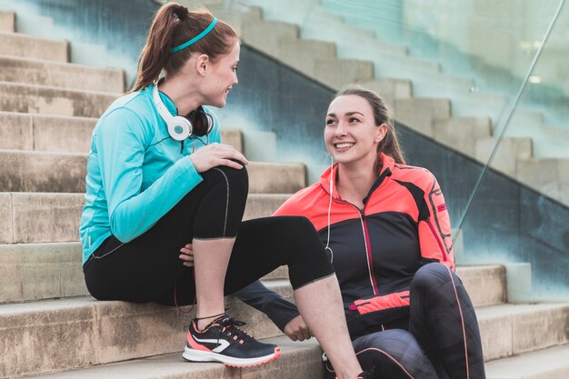 sporty women sitting on stairs