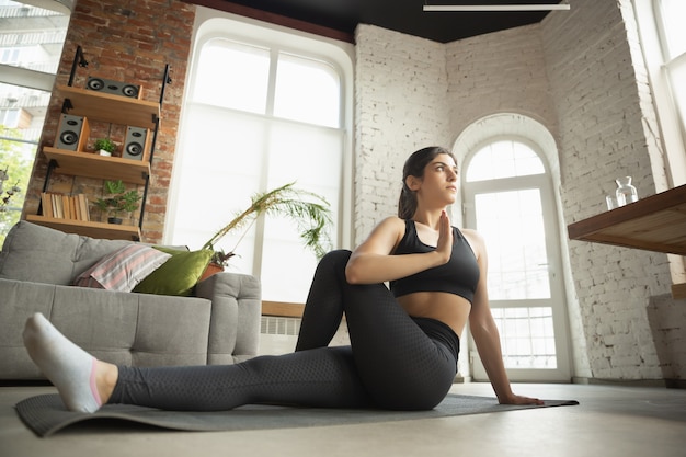 Foto gratuita giovane donna musulmana sportiva che prende lezioni di yoga a casa