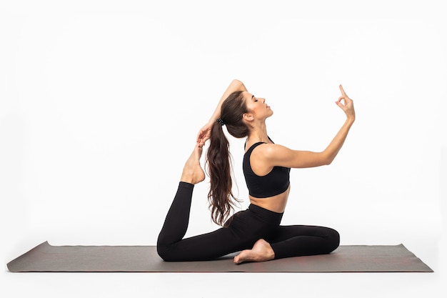 Sporty young woman doing yoga practice isolated on white surface - concept of healthy life and natural balance between body and mental development