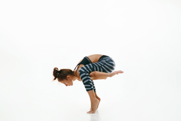 Sporty young woman doing yoga practice isolated on white