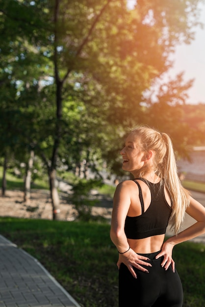 公園でポーズを取るスポーティな若い女性