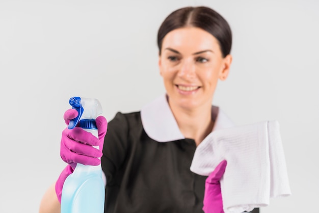 Spray of detergent in hand of maid in uniform