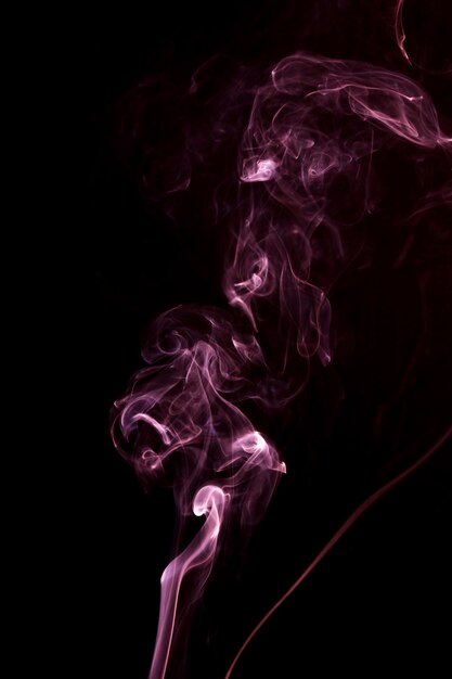 Spread of pink smoke on the black background