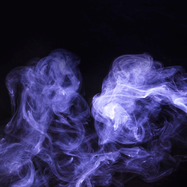 Распространение фиолетового дыма на черном фоне